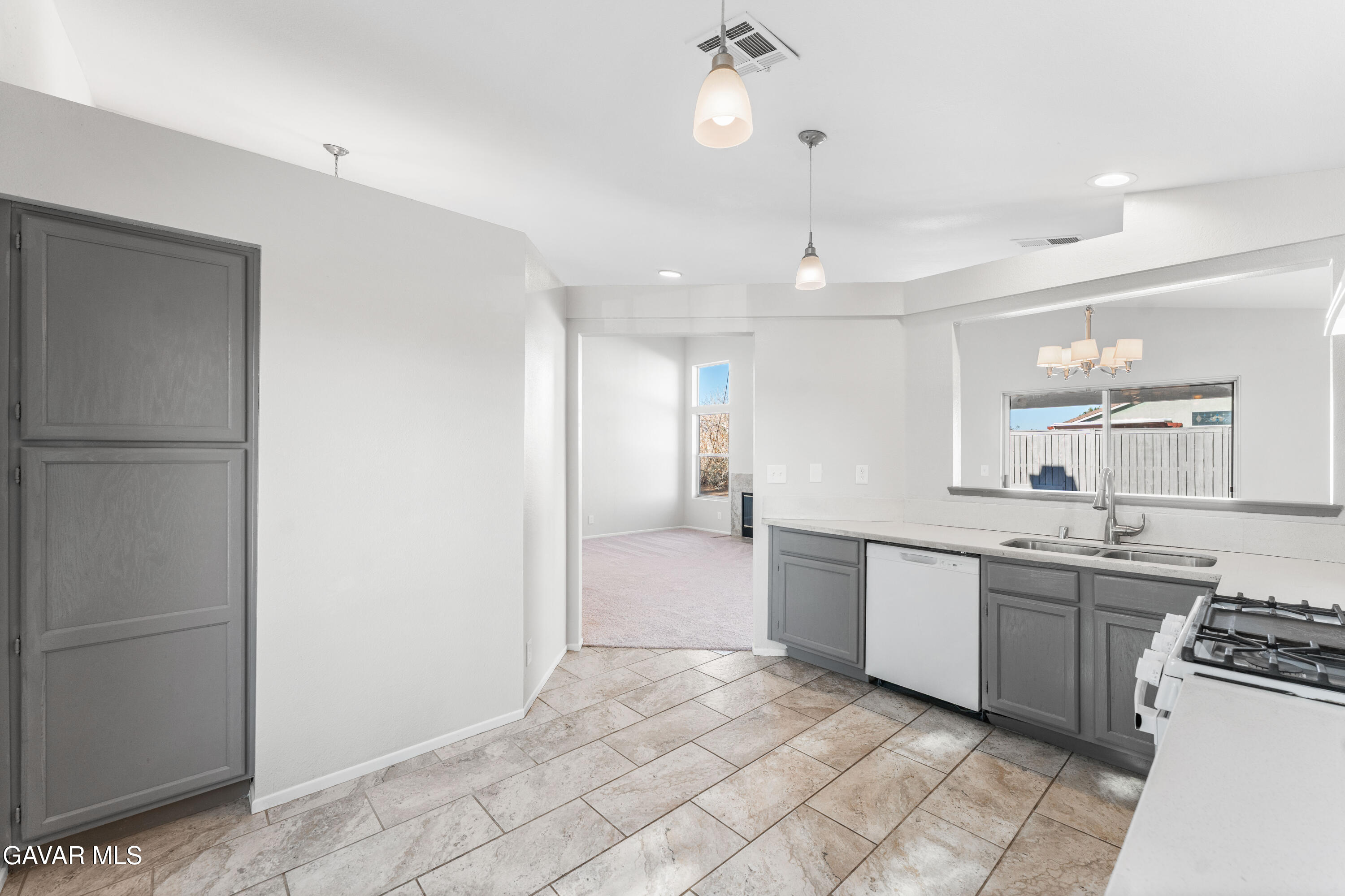 37031 Firethorn Street Palmdale, CA 93550 - Photo 18 of 36 a large white kitchen with a sink and dishwasher a refrigerator with white cabinets
