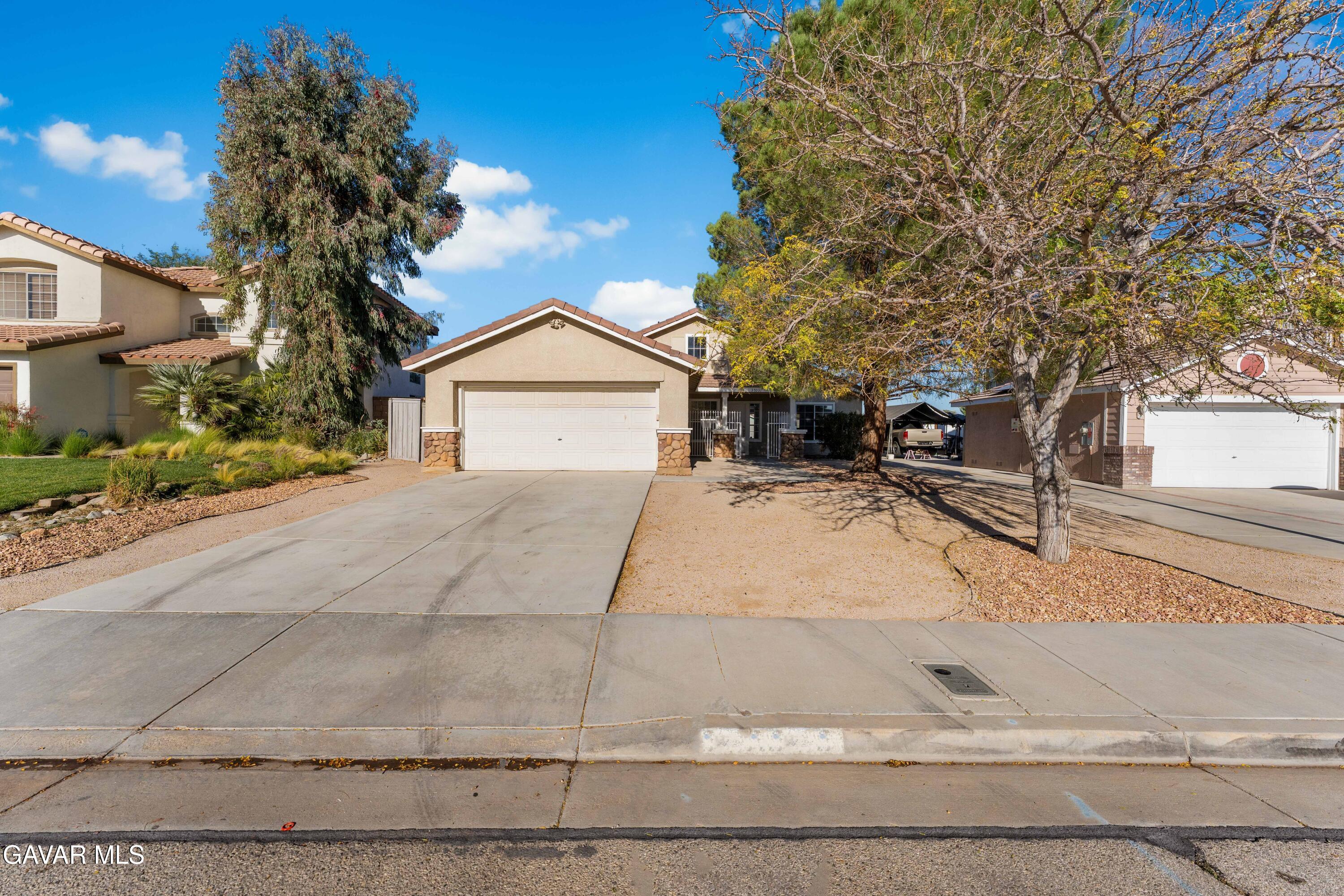 37031 Firethorn Street Palmdale, CA 93550 - Photo 2 of 36 a front view of a house with a yard and garage