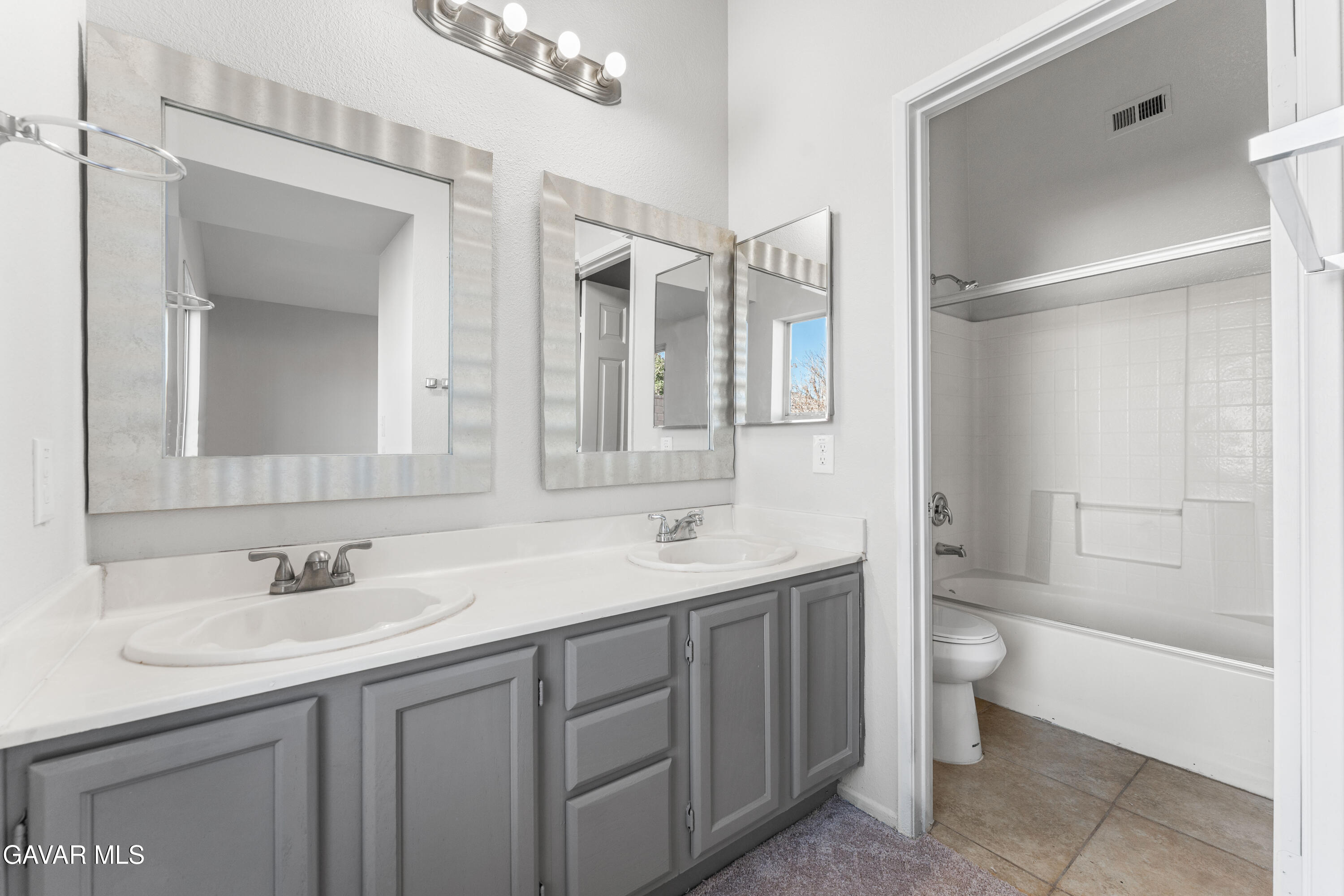 37031 Firethorn Street Palmdale, CA 93550 - Photo 26 of 36 a bathroom with a double vanity sink toilet and shower