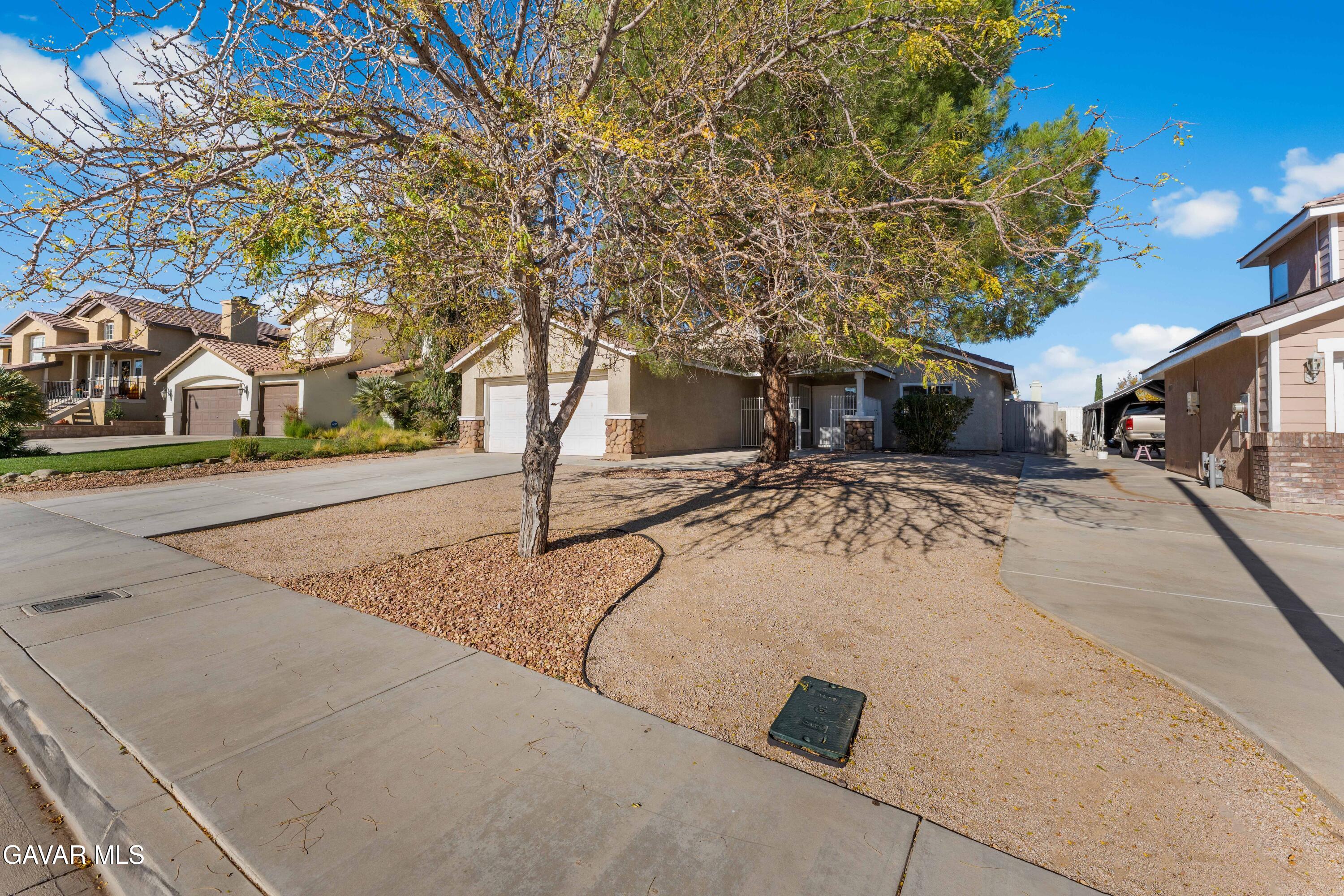 37031 Firethorn Street Palmdale, CA 93550 - Photo 4 of 36 a view of a white house with a snow on the road
