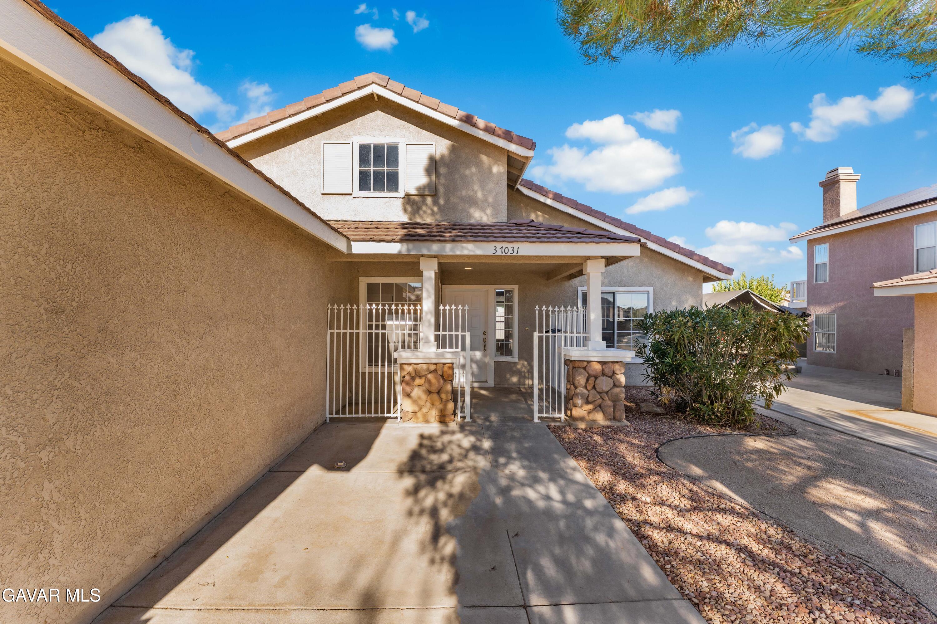 37031 Firethorn Street Palmdale, CA 93550 - Photo 6 of 36 a front view of a house with outdoor seating and yard