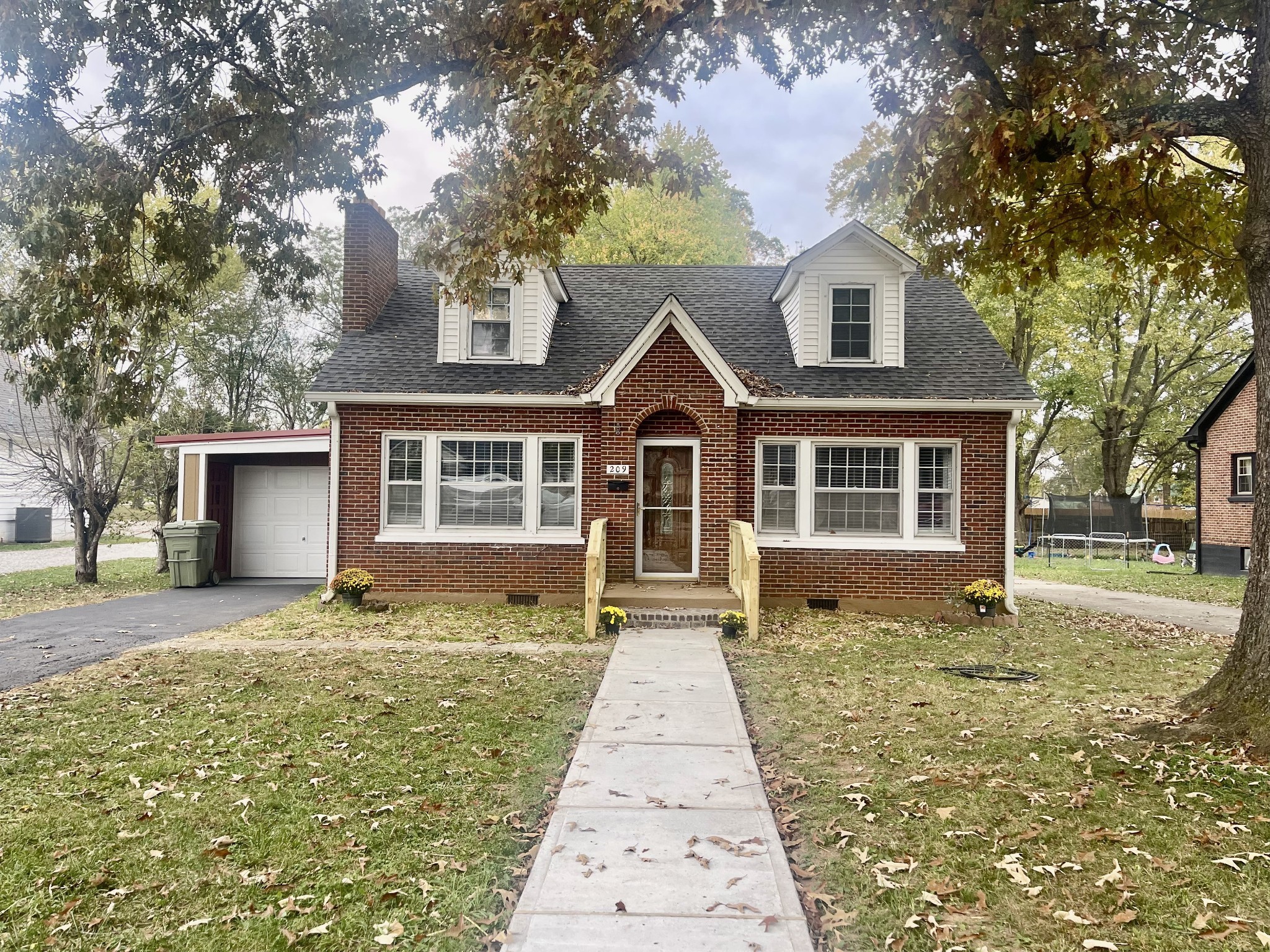 209 Frank Street Lawrenceburg, TN 38464 - Photo 2 of 34 a front view of a house with a garden and trees