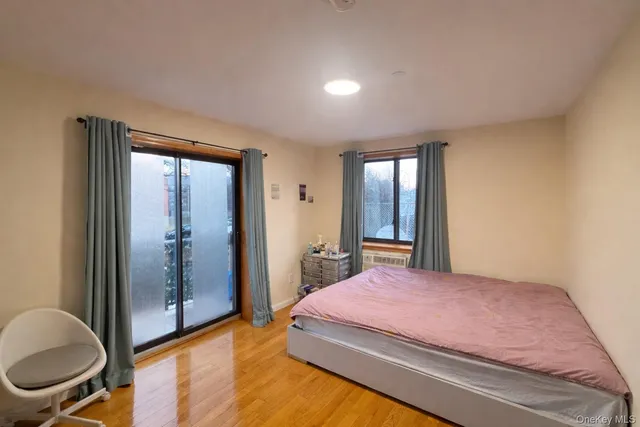 a bedroom with a bed and a dresser next to a window