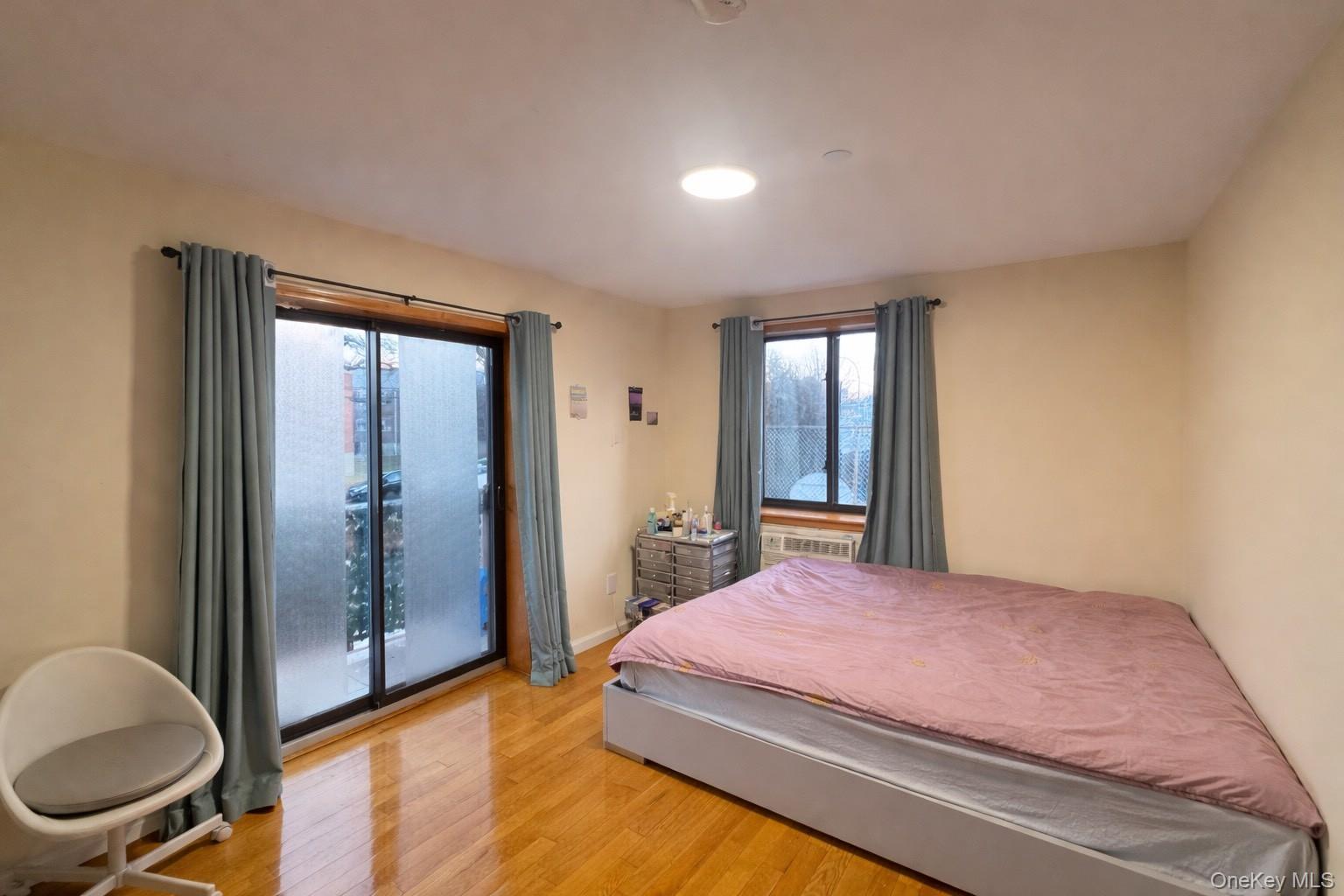 7548 Parsons Boulevard, Unit 2A Queens, NY 11366 - Photo 4 of 5 a bedroom with a bed and a dresser next to a window