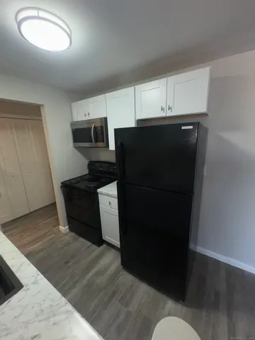 a view of kitchen with stainless steel appliances wooden floor