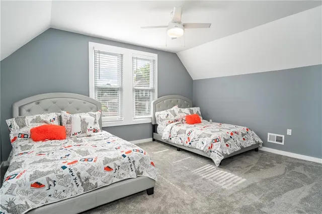 a bedroom with two beds and window