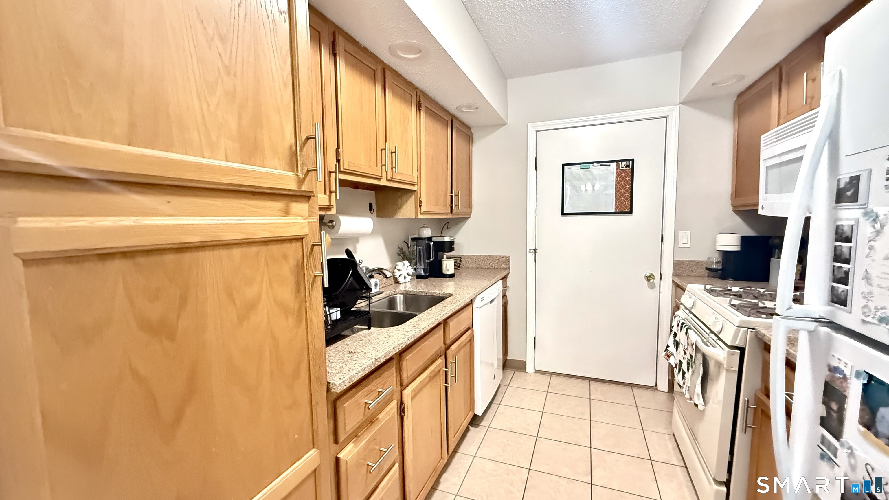 16 Maple Street, Unit 3 Vernon, CT 06066 - Photo 4 of 13 a kitchen with stainless steel appliances a stove a refrigerator a sink a counter space and cabinets
