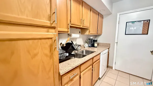 a kitchen with stainless steel appliances a sink a refrigerator and cabinets