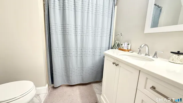 a bathroom with a sink a toilet and shower curtain