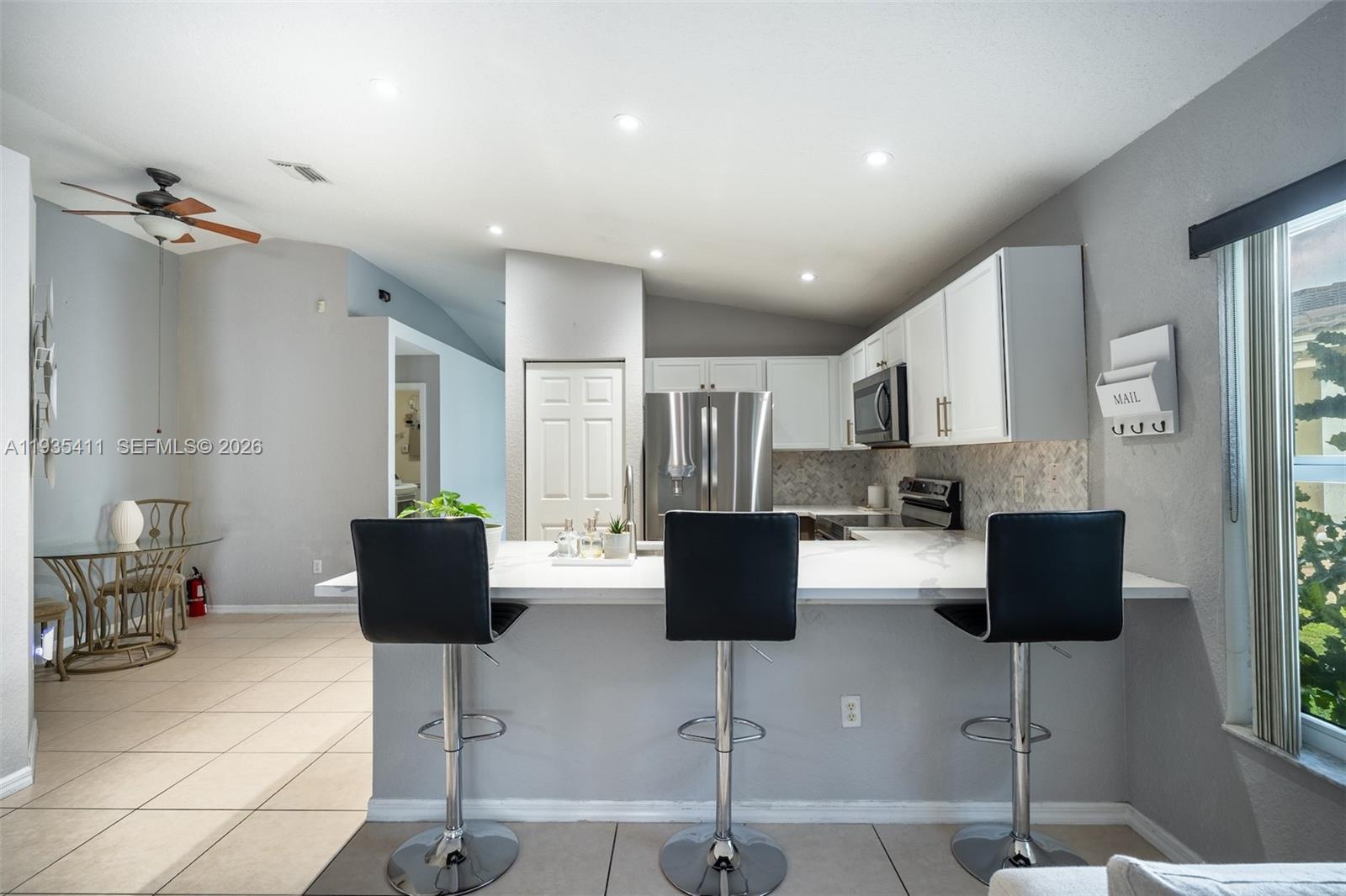 4521 Southwest 124th Terrace Miramar, FL 33027 - Photo 13 of 47 a kitchen with stainless steel appliances kitchen island granite countertop a refrigerator a stove a sink and white cabinets