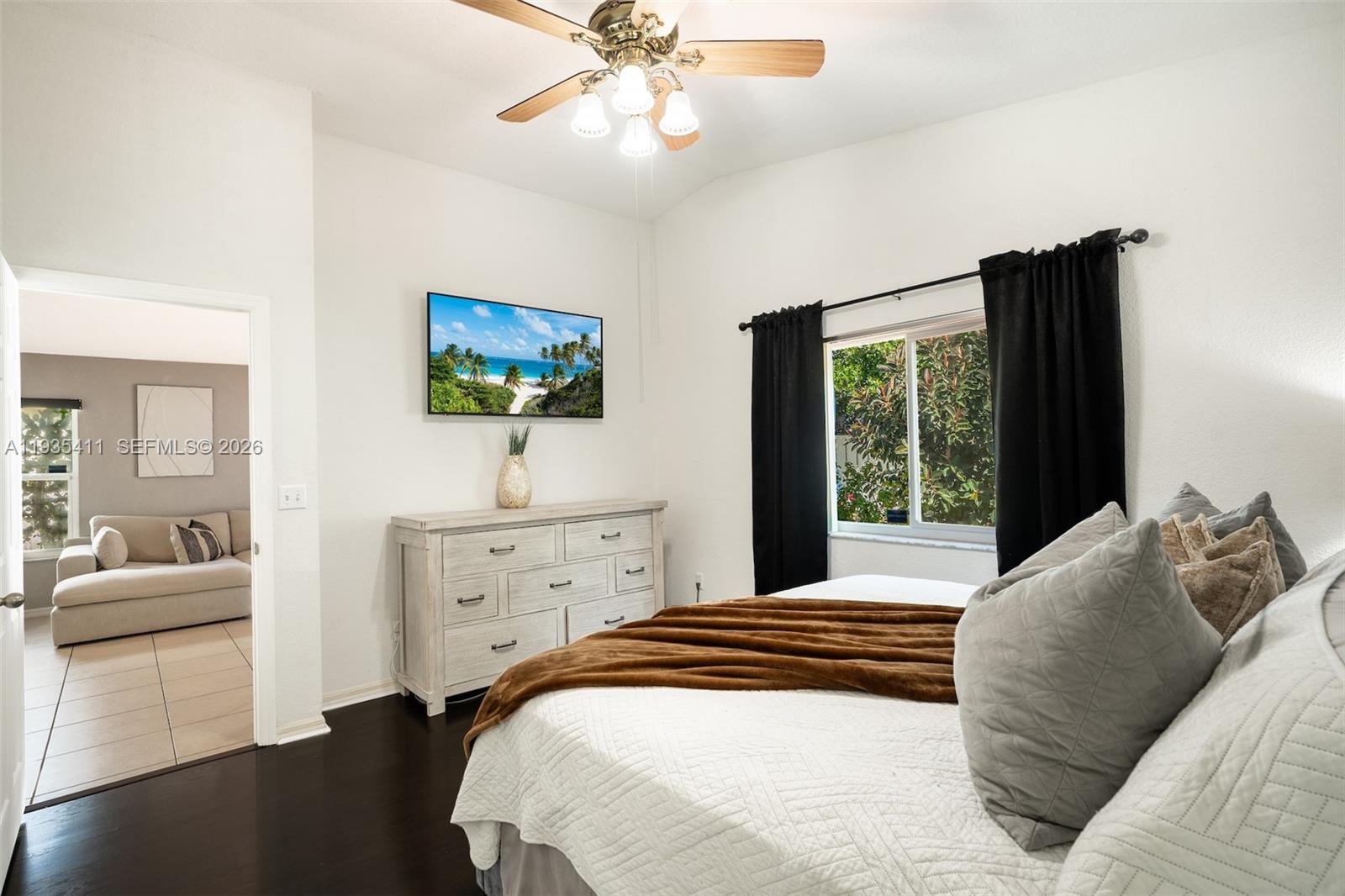 4521 Southwest 124th Terrace Miramar, FL 33027 - Photo 19 of 47 a bedroom with a large bed and a chandelier