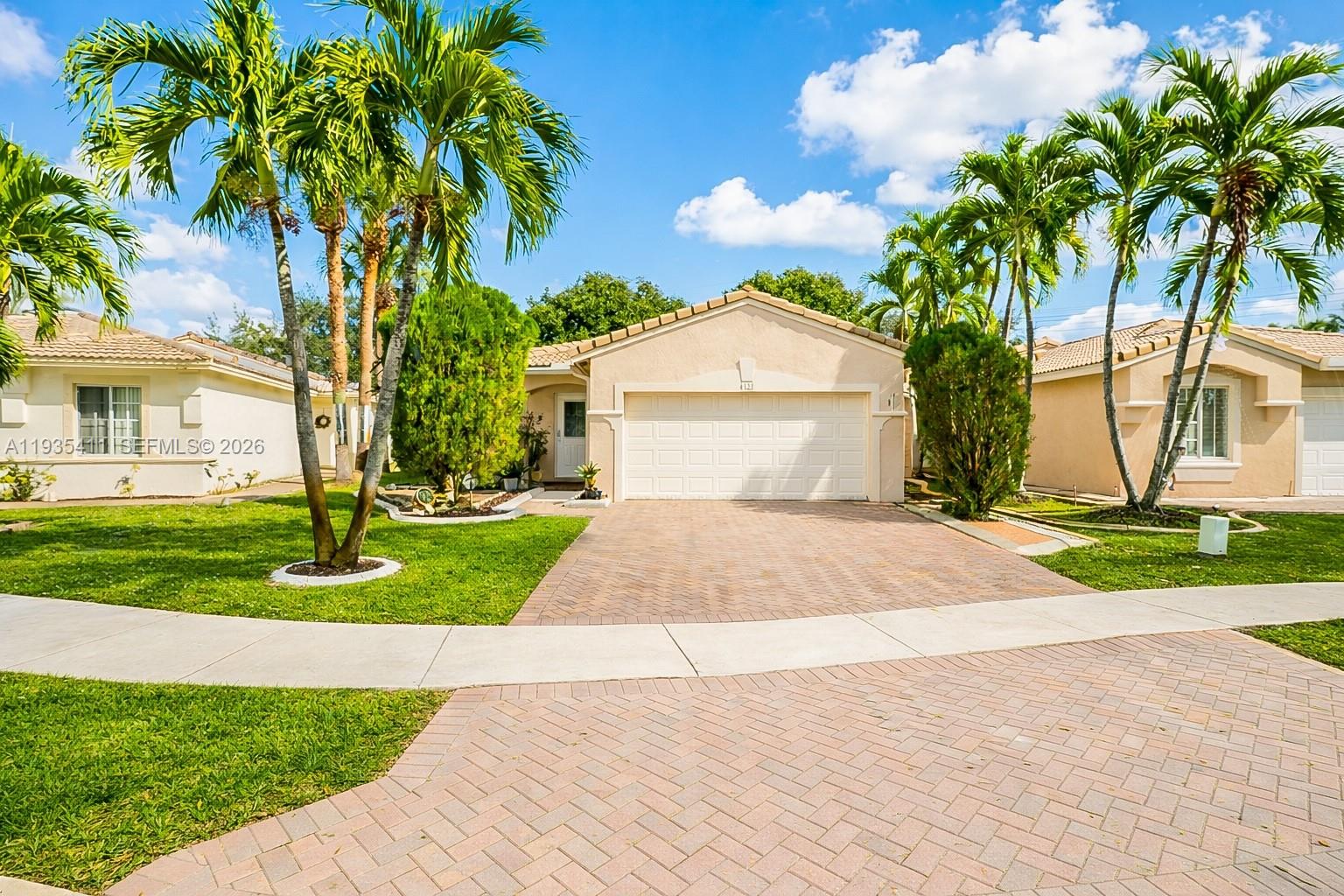 4521 Southwest 124th Terrace Miramar, FL 33027 - Photo 2 of 47 a front view of a house with a yard and potted plants