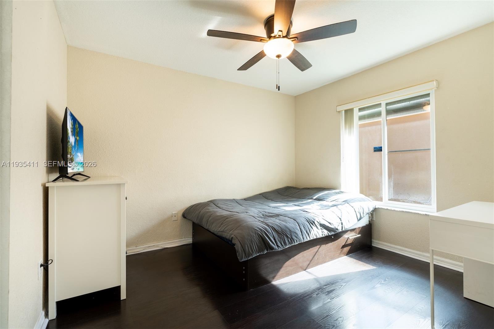4521 Southwest 124th Terrace Miramar, FL 33027 - Photo 21 of 47 a bedroom with a bed and a flat tv screen on the dresser