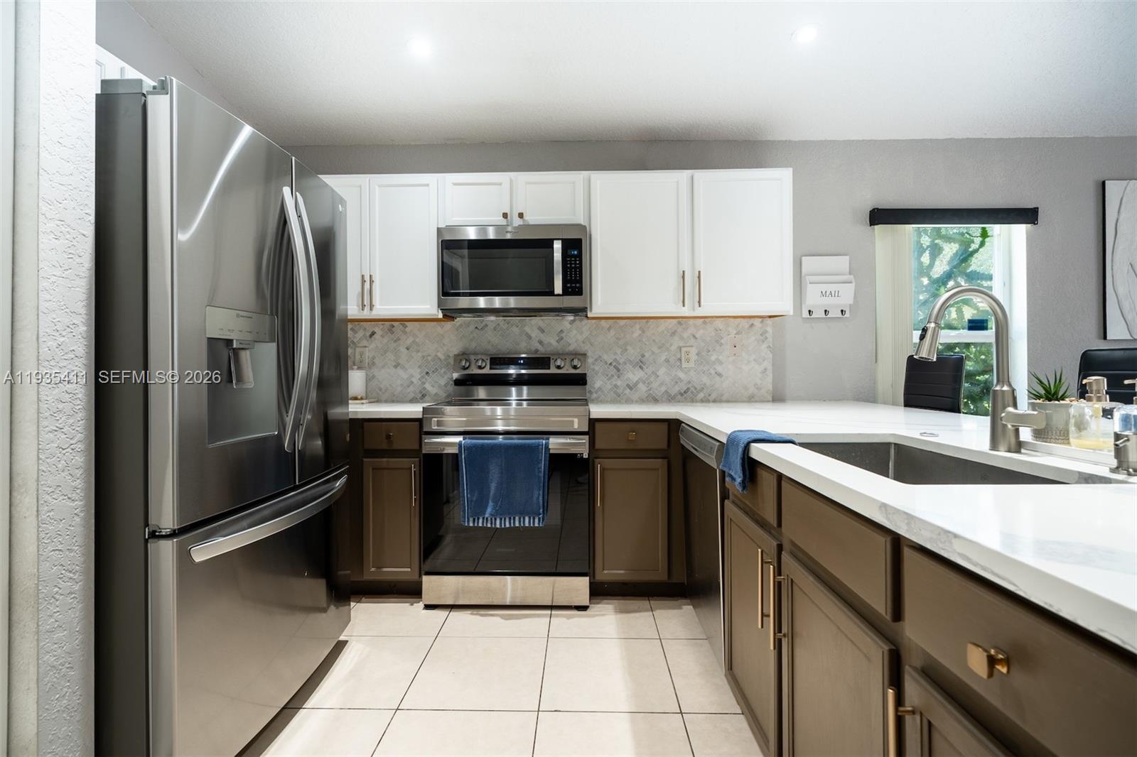 4521 Southwest 124th Terrace Miramar, FL 33027 - Photo 10 of 47 a kitchen with stainless steel appliances granite countertop a refrigerator sink and stove