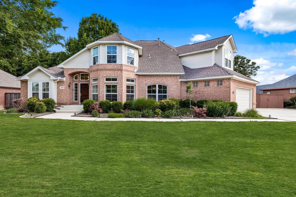 a front view of a house with a yard and potted plants