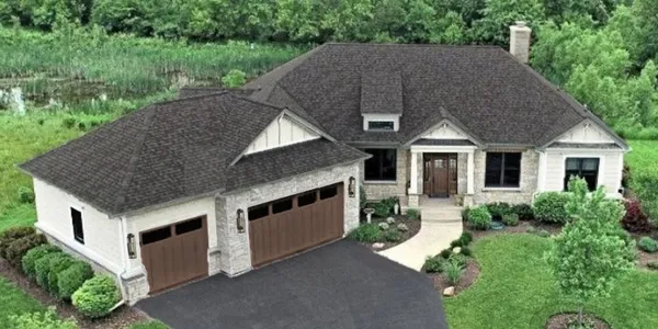 a aerial view of a house next to a big yard and large trees