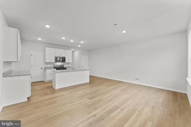 a view of kitchen with kitchen island white cabinets and wooden floor