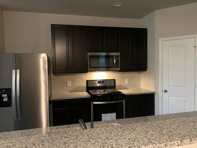 a kitchen with a refrigerator stove and microwave