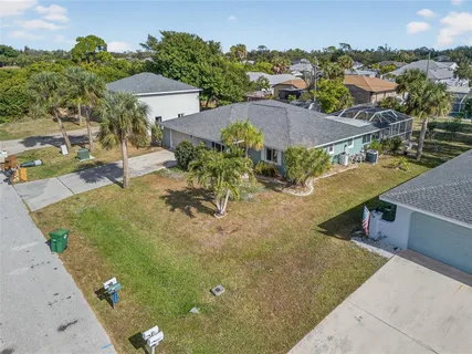 an aerial view of a house with yard and seating space