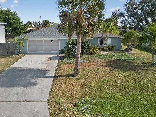 front view of a house with a yard and an trees