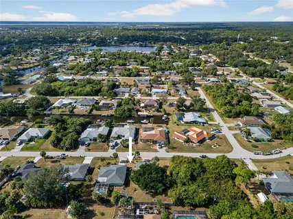 an aerial view of residential houses with outdoor space and trees