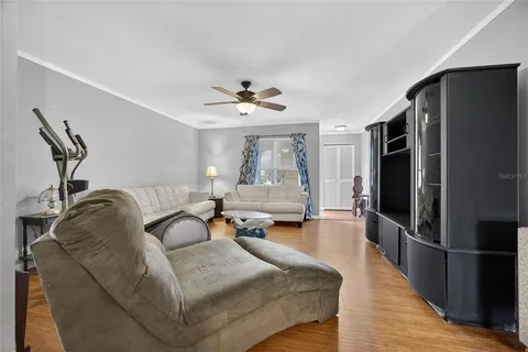 a living room with furniture a large window and stainless steel appliances