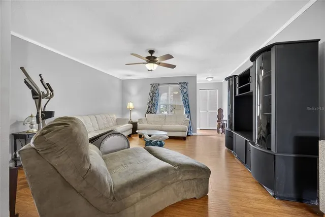 a living room with furniture a large window and stainless steel appliances