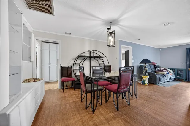 a view of a a dining room with furniture window and wooden floor