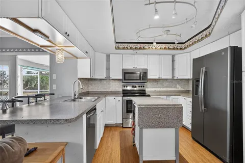 a kitchen with stainless steel appliances granite countertop a sink a stove and a refrigerator