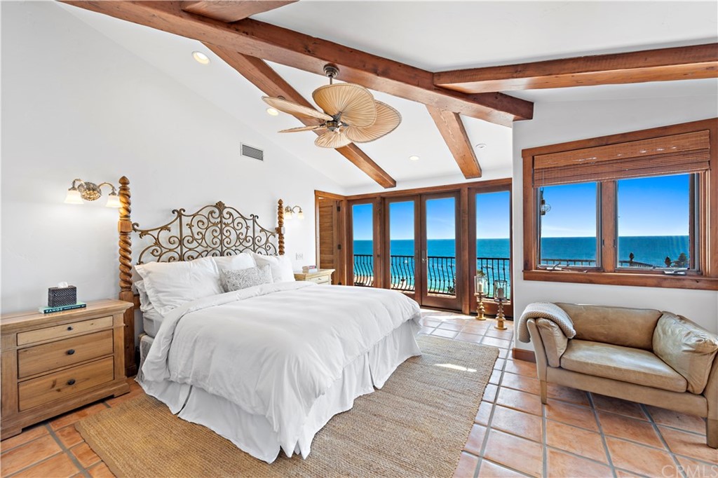111 Emerald Bay Laguna Beach, CA 92651 - Photo 28 of 60 a spacious bedroom with a bed a couch and a large window