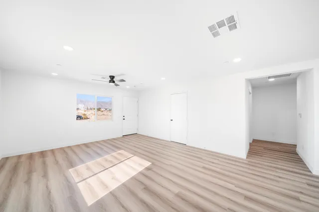 a view of a room with wooden floor and a ceiling fan