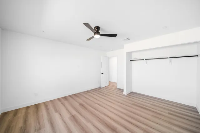 a view of a room with wooden floor and a ceiling fan