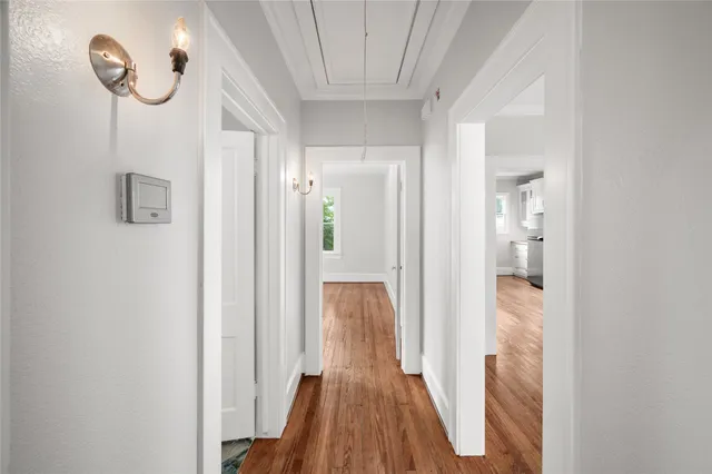 a view of a hallway with wooden floor and staircase