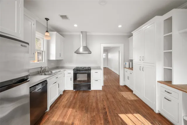 a kitchen with stainless steel appliances granite countertop a sink stove and wooden floor