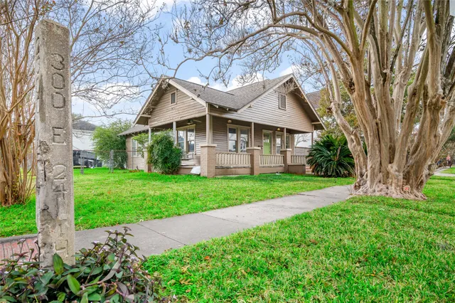 a view of a house next to a yard with big trees