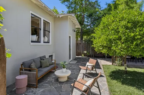 a view of a patio with couches table and chairs and potted plants
