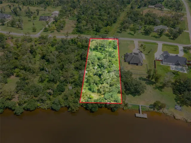 an aerial view of a house with a yard and lake view