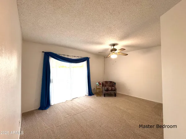 a view of an empty room with closet and a window