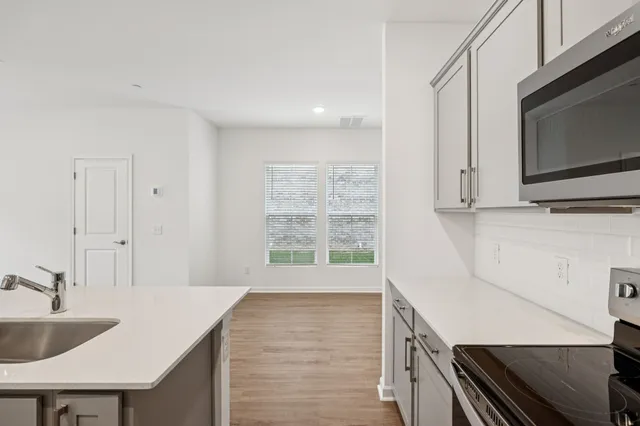 a kitchen with a sink a microwave and cabinets