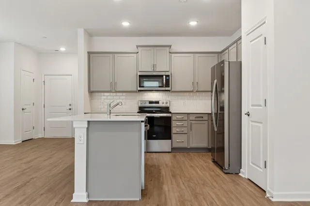 a kitchen with a refrigerator and a stove top oven