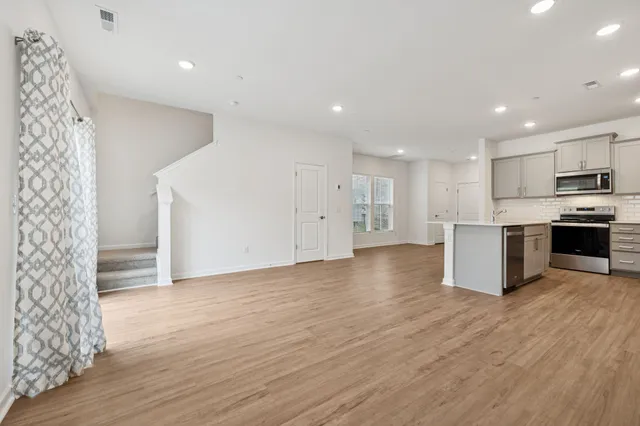 a view of kitchen with stainless steel appliances granite countertop a stove top oven a sink and a refrigerator