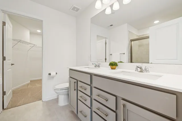 a bathroom with a double vanity sink toilet and shower