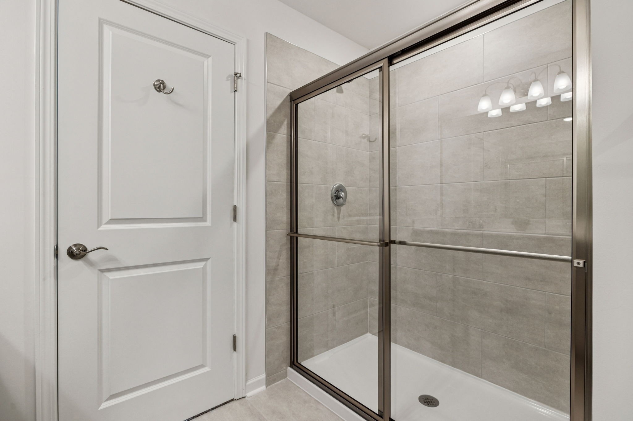 7148 Mapleside Lane Fairview, TN 37062 - Photo 24 of 39 a bathroom with a glass shower door