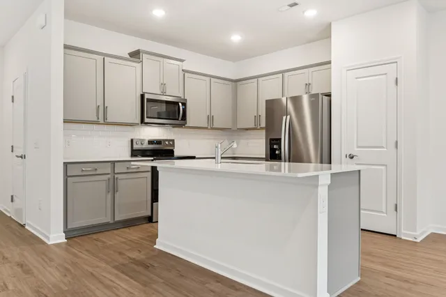 a kitchen with stainless steel appliances a refrigerator and a stove top oven