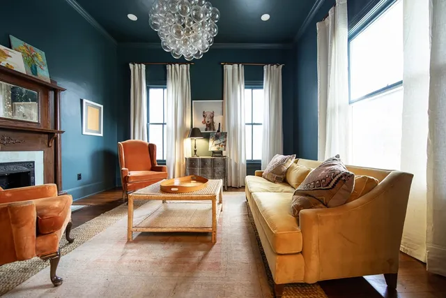 a living room with furniture kitchen view and a wooden floor