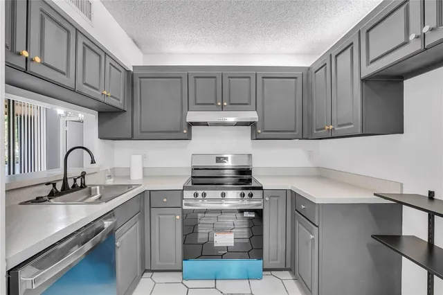 a kitchen with stainless steel appliances granite countertop a stove and a sink