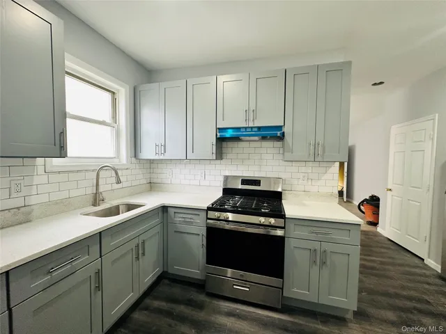 a kitchen with a sink stove and cabinets