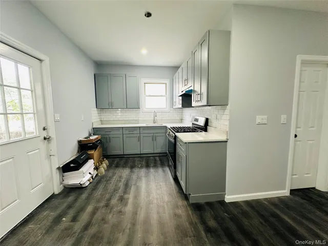 a kitchen with a sink wooden floor and view living room