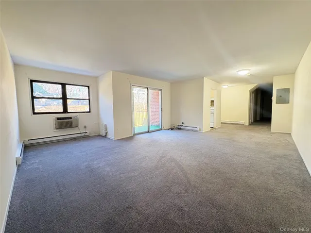 an empty room with windows and ceiling fan