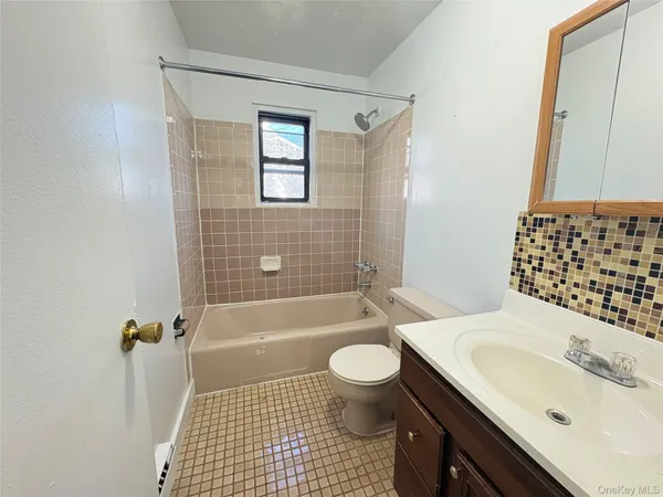a bathroom with a sink a toilet a tub and shower